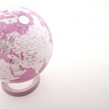 Illuminated terrestrial globe in white and coral design on coral-colored base